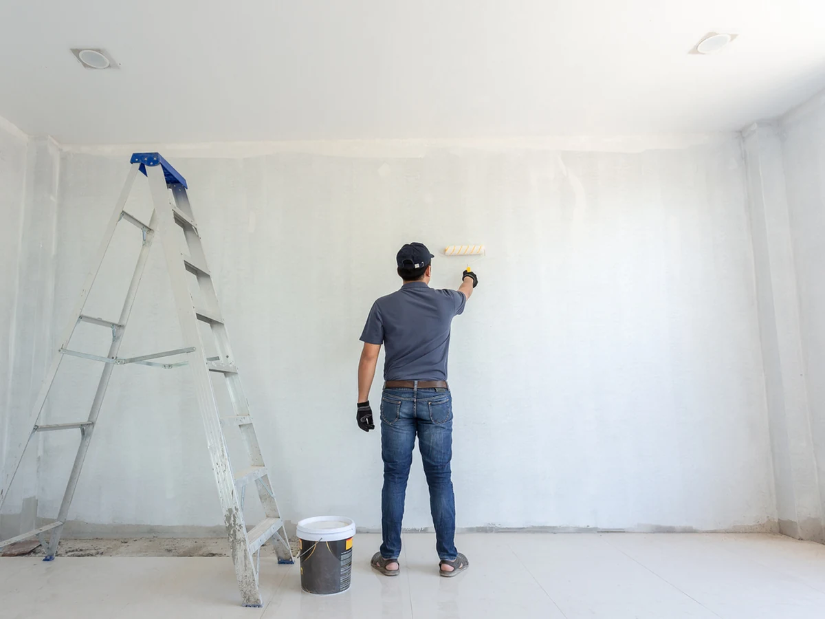 Painter in grey and white working on radiator painting project