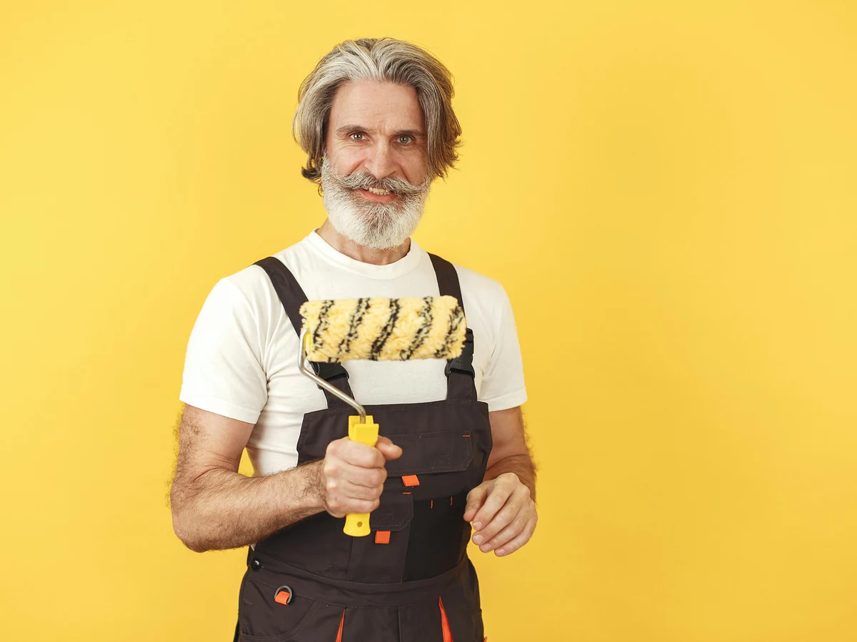 Friendly experienced painter preparing radiator for heat-resistant coating